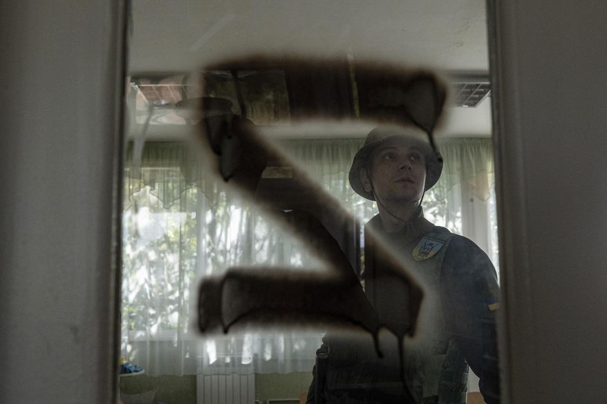 A Ukrainian serviceman inspects a kindergarten classroom with a sign &amp;quot;Z&amp;quot; on the door that was used by Russian forces in the recently retaken area of Kapitolivka, Ukraine, Sunday, Sept. 25, 2022. (AP Photo/Evgeniy Maloletka)