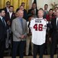 President Joe Biden holds up a jersey during an event celebrating the 2021 World Series champion Atlanta Braves, in the East Room of the White House, Monday, Sept. 26, 2022, in Washington. From left, Braves President of Baseball Operations Alex Anthopoulos, manager Brian Snitker, Biden, and Braves President and CEO Terry McGuirk. (AP Photo/Evan Vucci)