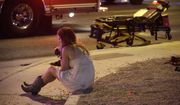 A woman sits on a curb on Oct. 2, 2017, at the scene of a shooting outside a music festival on Oct. 1 that killed 58 people and injured hundreds on the Las Vegas Strip. A new documentary, “11 Minutes,” is an inside account of the 2017 massacre at a country music concert in Las Vegas. More than three hours long, the four-part documentary debuts on the Paramount+ streaming service Tuesday. (AP Photo/John Locher, File)