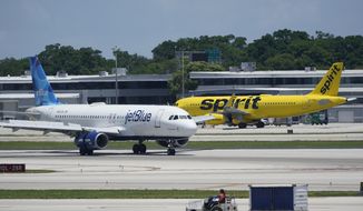 A JetBlue Airways Airbus A320, left, passes a Spirit Airlines Airbus A320 as it taxis on the runway, July 7, 2022, at the Fort Lauderdale-Hollywood International Airport in Fort Lauderdale, Fla. (AP Photo/Wilfredo Lee, File)