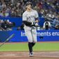 New York Yankees&#39; Aaron Judge tosses his bat as he is walked by Toronto Blue Jays starting pitcher Kevin Gausman during third-inning baseball game action in Toronto, Monday, Sept. 26, 2022. (Nathan Denette/The Canadian Press via AP)