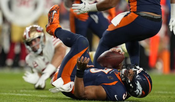 Denver Broncos quarterback Russell Wilson (3) is sacked by San Francisco 49ers defensive end Nick Bosa, rear, during the second half of an NFL football game in Denver, Sunday, Sept. 25, 2022. (AP Photo/Jack Dempsey)