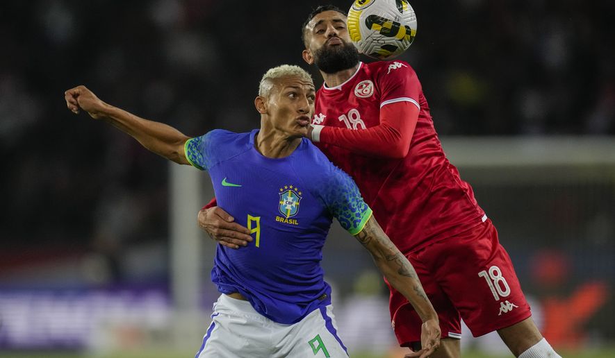 Tunisia&#39;s Ghaylen Chaaleli, right, duels for the ball with Brazil&#39;s Richarlison during the international friendly soccer match between Brazil and Tunisia at the Parc des Princes stadium in Paris, France, Tuesday, Sept. 27, 2022. (AP Photo/Christophe Ena)
