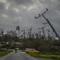 A classic American car drives past utility poles tilted by Hurricane Ian in Pinar del Rio, Cuba, Tuesday, Sept. 27, 2022. (AP Photo/Ramon Espinosa)