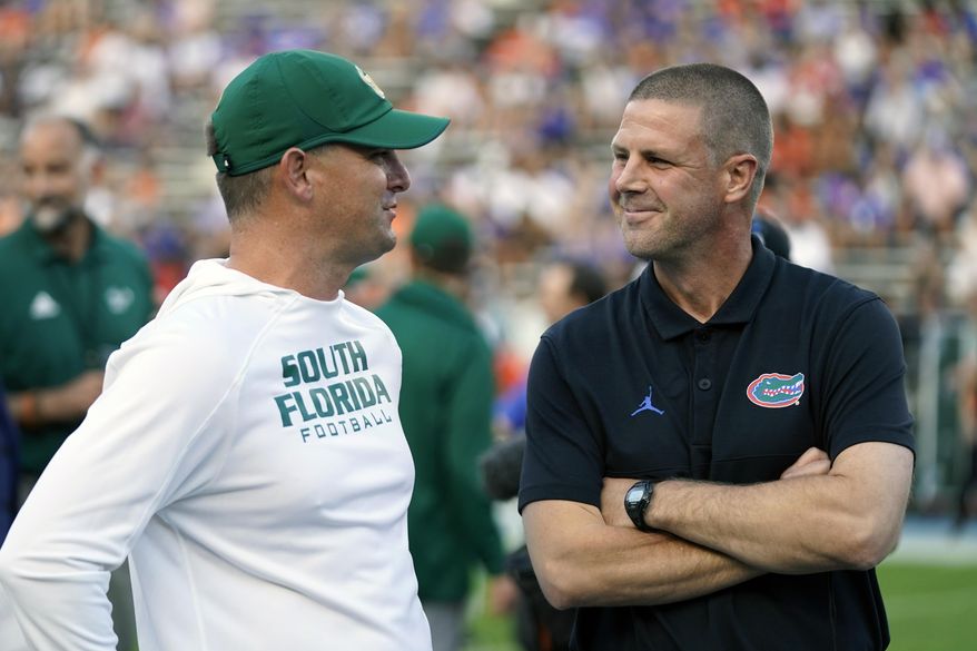 South Florida head coach Jeff Scott, left, and Florida head coach Billy Napier greet each other at midfield before an NCAA college football game, Saturday, Sept. 17, 2022, in Gainesville, Fla. (AP Photo/John Raoux) **FILE**