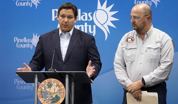 Florida Gov. Ron DeSantis, left, speaks as he stands with Kevin Guthrie, director of the Florida Division of Emergency Management, during a news conference, Monday, Sept. 26, 2022, in Largo, Fla. DeSantis was keeping residents updated on the track of Hurricane Ian. (AP Photo/Chris O&#39;Meara)