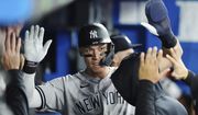 New York Yankees&#39; Aaron Judge is congratulated after scoring a run against the Toronto Blue Jays during the third inning of a baseball game Tuesday, Sept. 27, 2022, in Toronto. (Nathan Denette/The Canadian Press via AP)