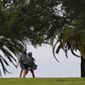 A couple walks along the waterfront that is seeing the effects of Hurricane Ian Wednesday, Sept. 28, 2022, in Saint Petersburg, Fla. (AP Photo/Steve Helber)