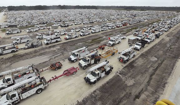Utility trucks are staged in a rural lot in The Villages of Sumter County, Fla., Wednesday, Sept. 28, 2022. Hurricane Ian rapidly intensified as it neared landfall along Florida&#39;s southwest coast Wednesday morning, gaining top winds of 155 mph (250 kph), just shy of the most dangerous Category 5 status.  (Stephen M. Dowell/Orlando Sentinel via AP)
