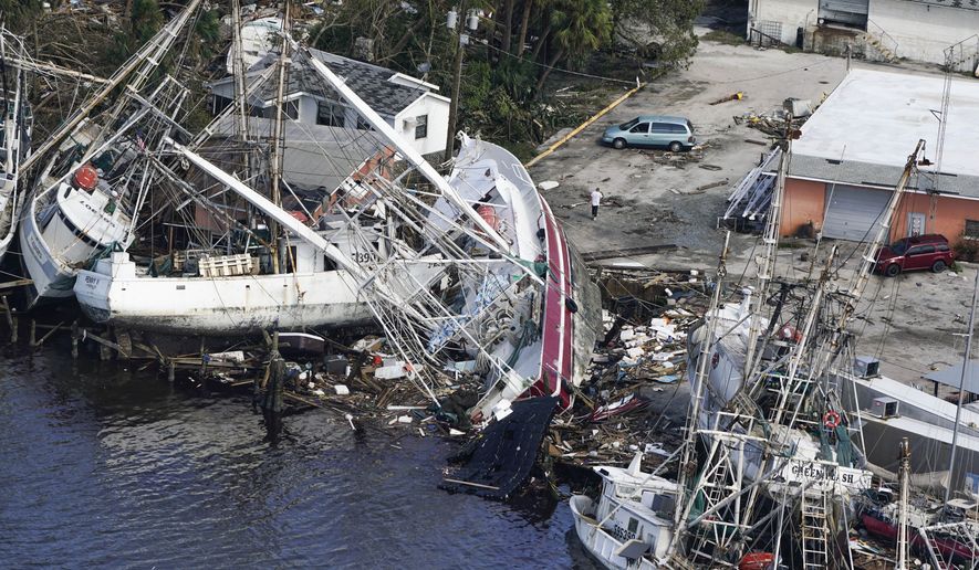 In this aerial photo, damaged boats and debris rest against the shore in the aftermath of Hurricane Ian, Thursday, Sept. 29, 2022, in Fort Myers, Fla.  (AP Photo/Wilfredo Lee)