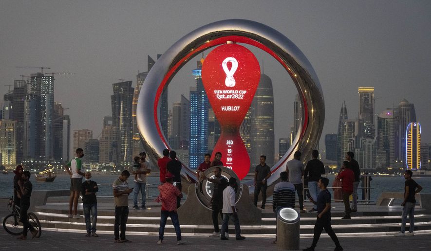 People gather around the official countdown clock showing remaining time until the kick-off of the World Cup 2022, in Doha, Qatar, Thursday, Nov. 25, 2021. Fans going to the World Cup in Qatar must show a negative COVID-19 test when they arrive as part of the host nation’s rules to combat COVID-19, organizers said Thursday, Sept. 29, 2022. (AP Photo/Darko Bandic) **FILE**