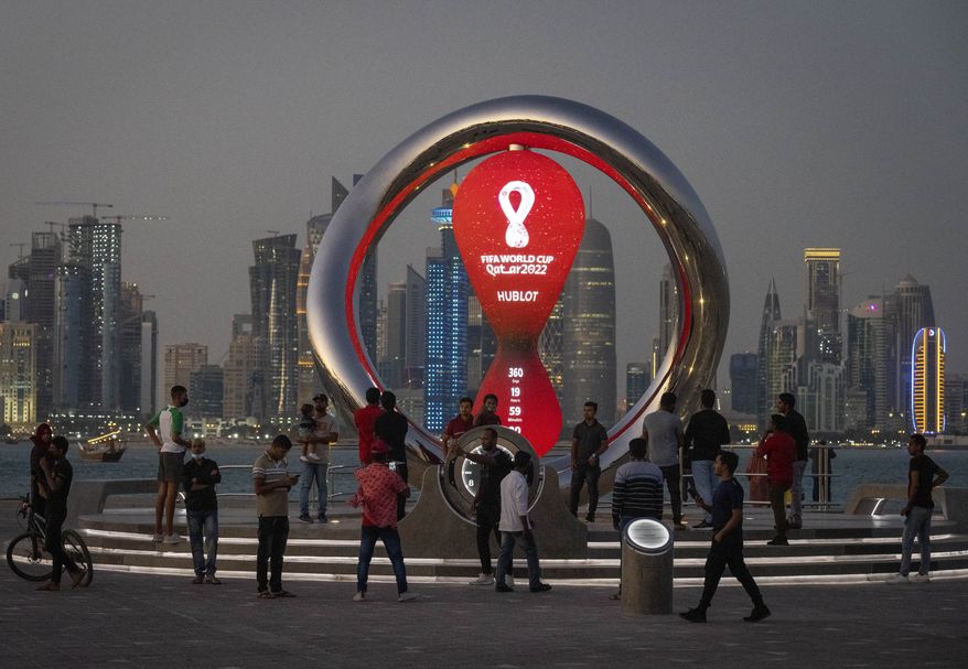 People gather around the official countdown clock showing remaining time until the kick-off of the World Cup 2022, in Doha, Qatar, Thursday, Nov. 25, 2021. Fans going to the World Cup in Qatar must show a negative COVID-19 test when they arrive as part of the host nation’s rules to combat COVID-19, organizers said Thursday, Sept. 29, 2022. (AP Photo/Darko Bandic) **FILE**