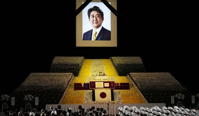 A portrait of former Japanese Prime Minister Shinzo Abe hangs on the stage during his state funeral, Tuesday, Sept. 27, 2022, Tokyo. Abe was assassinated in July. (Franck Robichon/Pool Photo via AP)