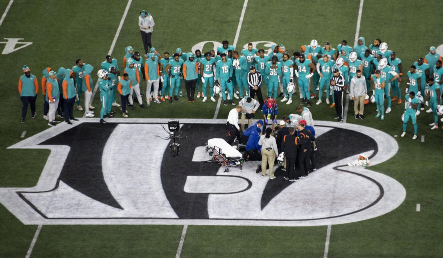 Teammates gather around Miami Dolphins quarterback Tua Tagovailoa (1) after an injury during the first half of an NFL football game against the Cincinnati Bengals, Thursday, Sept. 29, 2022, in Cincinnati. (AP Photo/Emilee Chinn)