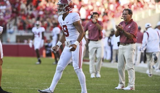 Alabama quarterback Bryce Young and coach Nick Saban celebrate a touchdown against Arkansas during the second half of an NCAA college football game Saturday, Oct. 1, 2022, in Fayetteville, Ark. Young left the game in the first half after an injury. (AP Photo/Michael Woods)