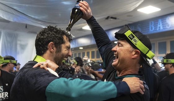 Seattle Mariners manager Scott Servais, right, celebrates in the clubhouse after the team&#39;s baseball game against the Oakland Athletics, Friday, Sept. 30, 2022, in Seattle. The Mariners won 2-1 to clinch a spot in the playoffs. (AP Photo/Stephen Brashear)