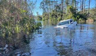 A car is submerged in flood water in North Port, Fla., on Friday, Sept. 30, 2022. (AP Photo/Adriana Gomez Licon)