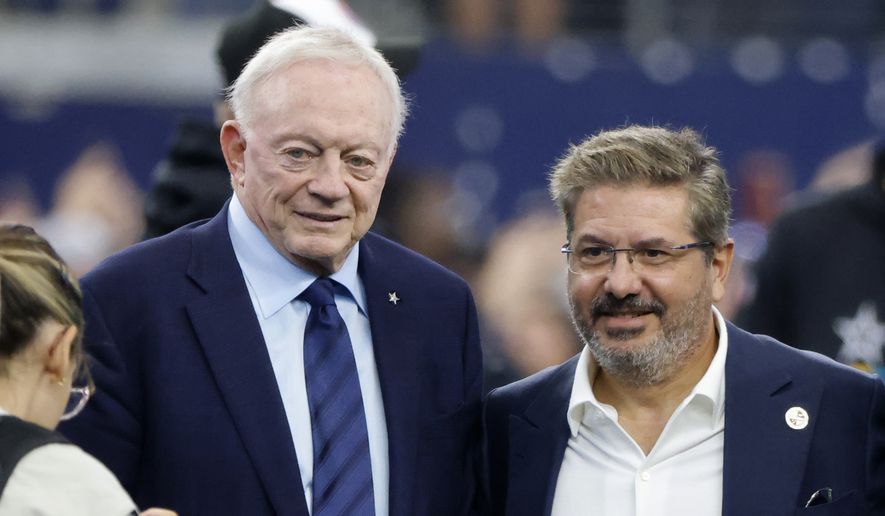 Dallas Cowboys team owner Jerry Jones and Dan Snyder, co-owner and co-CEO of the Washington Commanders, pose for a photo on the field during warmups before an NFL football game in Arlington, Texas, Sunday, Oct. 2, 2022. (AP Photo/Michael Ainsworth) ** FILE **