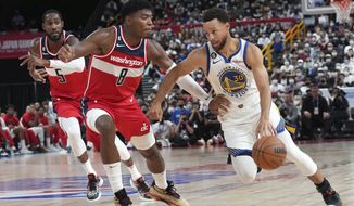 Golden State Warriors&#39; Stephen Curry, right, and Washington Wizards&#39; Rui Hachimura, left, fight for the ball during a preseason NBA basketball game between Golden State Warriors and Washington Wizards Sunday, Oct. 2, 2022, at Saitama Super Arena, in Saitama, north of Tokyo. (AP Photo/Eugene Hoshiko)