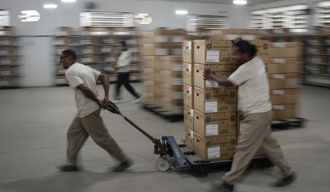 Electoral workers move electronic voting machine boxes at a distribution center in Rio de Janeiro, Brazil, Saturday, Oct. 1, 2022. Brazil&#x27;s general elections are scheduled for Oct. 2. Brazilians head to polls on Oct. 2 to elect a president, vice president, governors and senators. (AP Photo/Matias Delacroix)