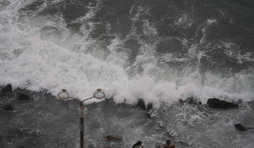 People relax at the beach front in Mazatlan, Mexico, Sunday, Oct. 2, 2022. Hurricane Orlene, at Category 3 strength, is heading for a collision with Mexico&#39;s northwest Pacific coast between the tourist towns of Mazatlan and San Blas. (AP Photo/Fernando Llano)