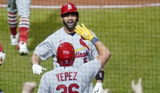 St. Louis Cardinals&#39; Albert Pujols, top, celebrates with Juan Yepez as he heads to the dugout after he hit home run No. 703 in his career during the fifth inning of a baseball game against the Pittsburgh Pirates, Monday, Oct. 3, 2022, in Pittsburgh. (AP Photo/Keith Srakocic)