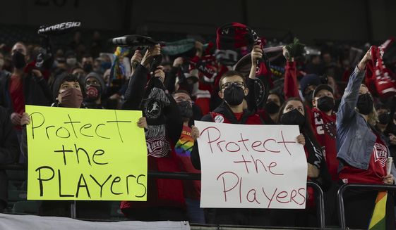 Portland Thorns fans hold signs during the first half of the team&#39;s NWSL soccer match against the Houston Dash in Portland, Ore., Wednesday, Oct. 6, 2021. An independent investigation into the scandals that erupted in the National Women&#39;s Soccer League last season found emotional abuse and sexual misconduct were systemic in the sport, impacting multiple teams, coaches and players, according to a report released Monday, Oct. 3, 2022. (AP Photo/Steve Dipaola, File) **FILE**