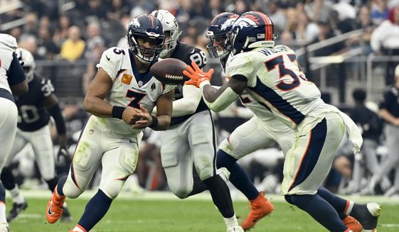 Denver Broncos quarterback Russell Wilson (3) hands off to running back Javonte Williams (33) during the second half of an NFL football game against the Las Vegas Raiders, Sunday, Oct. 2, 2022, in Las Vegas. (AP Photo/David Becker) **FILE**
