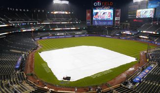 Security stands on the field as rain falls before a baseball game between the New York Mets and the Washington Nationals, Monday, Oct. 3, 2022, in New York. (AP Photo/Frank Franklin II)