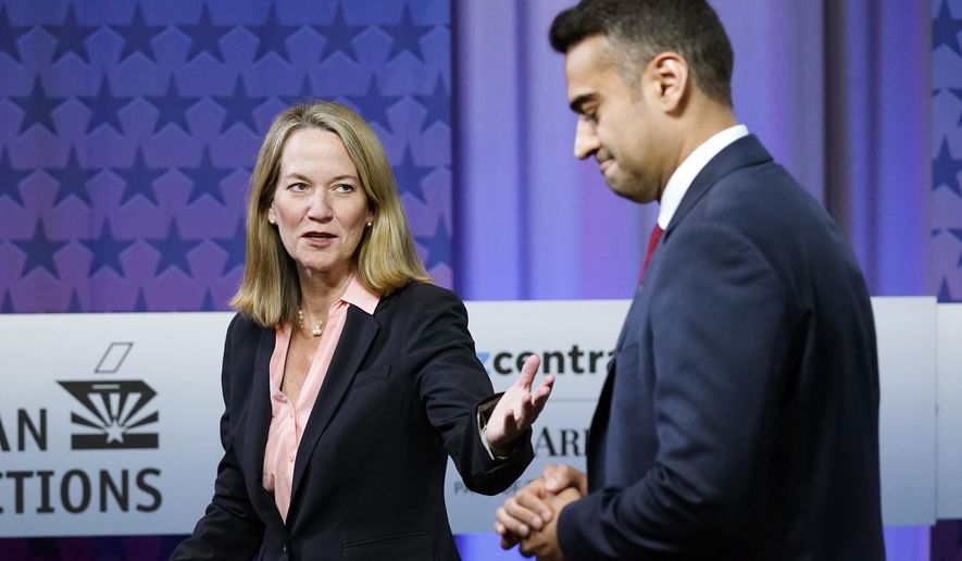 Arizona Attorney General candidates, Democrat Kris Mayes, left, talks with Republican Abraham Hamadeh, right, prior to a televised debate, Wednesday, Sept. 28, 2022. (AP Photo/Ross D. Franklin)
