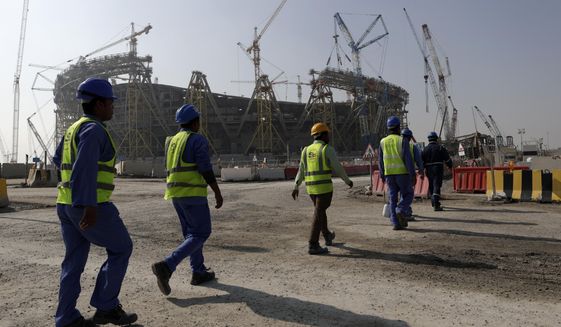 FILE - Workers walk to the Lusail Stadium, one of the 2022 World Cup stadiums, in Lusail, Qatar, Friday, Dec. 20, 2019. Paris has decided not to display the matches of the World Cup in Qatar on giant screens in fan zones amid concerns over rights violations of migrant workers and the environmental impact of the tournament that have led some other French cities to make the same decision. (AP Photo/Hassan Ammar, File)