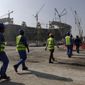 FILE - Workers walk to the Lusail Stadium, one of the 2022 World Cup stadiums, in Lusail, Qatar, Friday, Dec. 20, 2019. Paris has decided not to display the matches of the World Cup in Qatar on giant screens in fan zones amid concerns over rights violations of migrant workers and the environmental impact of the tournament that have led some other French cities to make the same decision. (AP Photo/Hassan Ammar, File)
