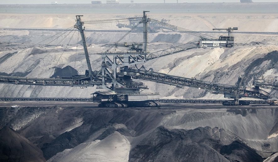 FILE - Giant bucket-wheel excavators extract coal at the controversial RWE Garzweiler surface coal mine near Jackerath, west Germany, Thursday, April 29, 2021. German energy giant RWE says it will phase out the burning of coal by 2030, saving 280 million metric tons of climate-changing greenhouse gas emissions. The decision announced Tuesday will accelerate the closure of some of Europe’s most polluting power plants and a vast lignite strip mine in the west of the country. (AP Photo/Martin Meissner, File)