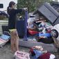 Alice Pujols goes through someone else&#39;s discarded items for clothes and shoes for her family Monday, Oct. 3, 2022, in Fort Myers, Fla. Pujols&#39;s home was completely destroyed after her home flooded due to rising waters caused by Hurricane Ian. (AP Photo/Marta Lavandier)