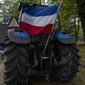 The Dutch flag flies upside down from a tractor during a small protest outside parliament, where Johan Remkes, an independent mediator, delivered his report into the Dutch government&#39;s plans to drastically reduce emissions of nitrogen pollutants by the country&#39;s agricultural sector during a press conference in The Hague, Netherlands, Wednesday, Oct. 5, 2022. The plans have sparked nationwide protests by angry farmers who fear for their livelihoods. (AP Photo/Peter Dejong)