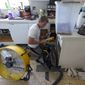 Jordan Cromer cleans water-logged items at his home, Tuesday, Oct. 4, 2022, in North Port, Fla. Residents along Florida&#39;s west coast are cleaning up damage after Hurricane Ian make landfall the week before. (AP Photo/Chris O&#39;Meara)