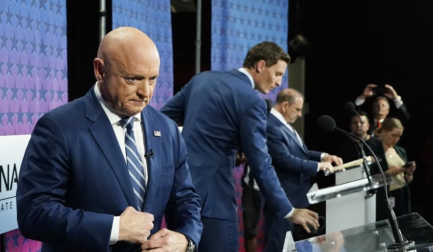 Arizona Democratic Sen. Mark Kelly, left, Republican candidate Blake Masters, middle, Libertarian candidate Marc Victor, right, pause on the stage prior to a televised debate for the Arizona Senate race in Phoenix, Thursday, Oct. 6, 2022. (AP Photo/Ross D. Franklin)