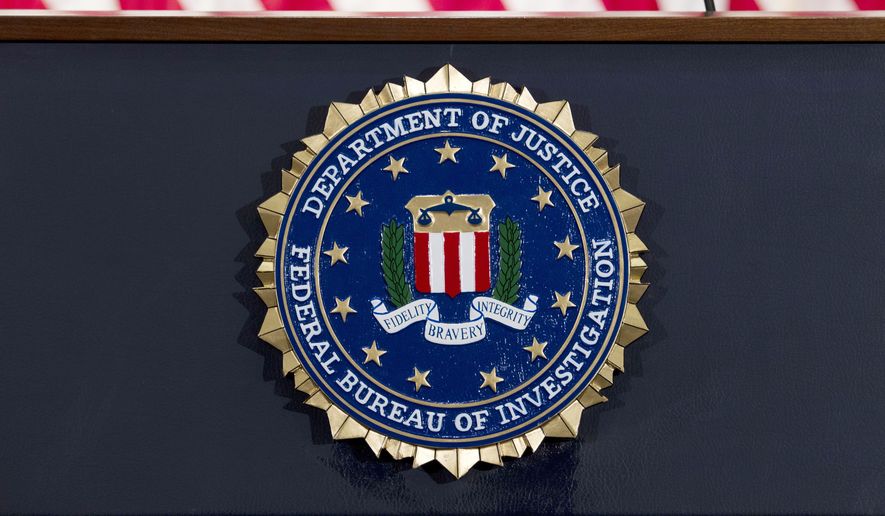 The FBI seal is displayed on a podium before a news conference at the agency's headquarters on June 14, 2018, in Washington. (AP Photo/Jose Luis Magana, File)