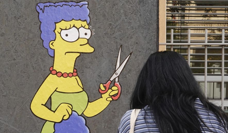 A woman takes pictures of a mural called &amp;quot;The Cut&amp;quot; by street artist aleXsandro Palombo depicting Marge Simpson, a character of the animated television series &amp;quot;The Simpsons&amp;quot; cutting her iconic hair, in front of the Consulate of Iran, in Milan, Italy, Wednesday, Oct. 5, 2022. Thousands of Iranians have taken to the streets over the last two weeks to protest the death of Mahsa Amini, a 22-year-old woman who had been detained by Iran&#39;s morality police in the capital of Tehran for allegedly not adhering to Iran&#39;s strict Islamic dress code. (AP Photo/Luca Bruno)
