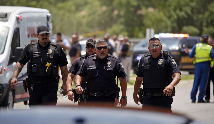 Police walk near Robb Elementary School following a shooting, May 24, 2022, in Uvalde, Texas. Four months after the Robb Elementary School shooting, the Uvalde school district on Friday, Oct. 7 pulled its entire embattled campus police force off the job following a wave of new outrage over the hiring of a former Texas state trooper who was part of the hesitant law enforcement response as a gunman killed 19 children and two teachers.  (AP Photo/Dario Lopez-Mills, File)