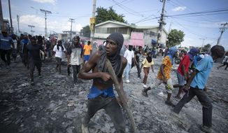FILE - A protester carries a piece of wood simulating a weapon during a protest demanding the resignation of Prime Minister Ariel Henry, in the Petion-Ville area of Port-au-Prince, Haiti, Oct. 3, 2022. Haiti&#39;s government has agreed to request the help of international armed forces as gangs and protesters paralyze the country and basic supplies including fuel and water dwindle, a top ranking Haitian official told The Associated Press on Friday, Oct 7. (AP Photo/Odelyn Joseph, File)