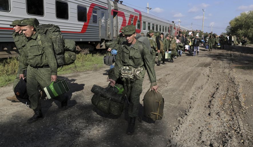 FILE - Russian recruits walk to take a train at a railway station in Prudboi, Volgograd region of Russia, Thursday, Sept. 29, 2022. Russian President Vladimir Putin has ordered a partial mobilization of reservists to beef up his forces in Ukraine. With the Russian army retreating under the blows of Ukrainian forces armed with Western weapons, Putin raised the stakes by annexing four Ukrainian regions and declaring a partial mobilization of up to 300,000 reservists to buttress the crumbling frontline. (AP Photo, File)