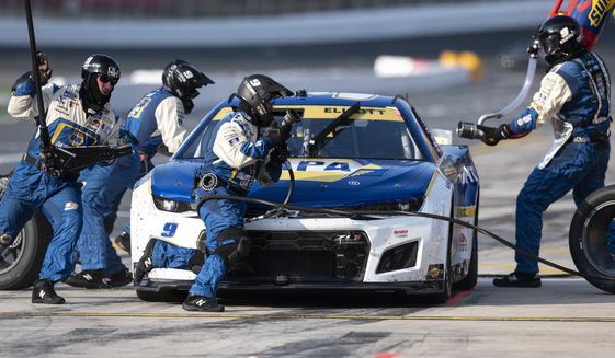 The pit crew of Chase Elliott (9) race to complete a pit stop during a NASCAR Cup Series auto race at Charlotte Motor Speedway, Sunday, Oct. 9, 2022, in Concord, N.C. (AP Photo/Matt Kelley)