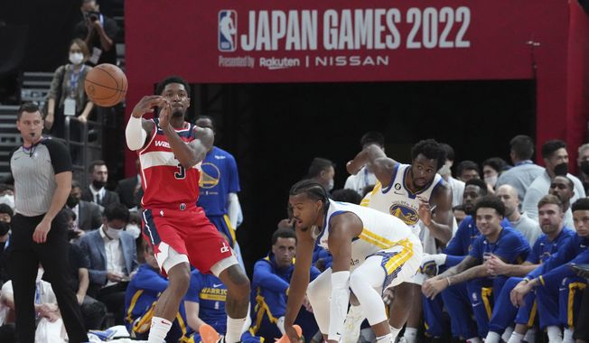 Washington Wizards&#x27; Bradley Beal, left, passes the ball around Golden State Warriors&#x27; Moses Moody, front right, and Andrew Wiggins during the preseason NBA basketball game, Friday, Sept. 30, 2022, at Saitama Super Arena, in Saitama, north of Tokyo. (AP Photo/Eugene Hoshiko) **FILE**