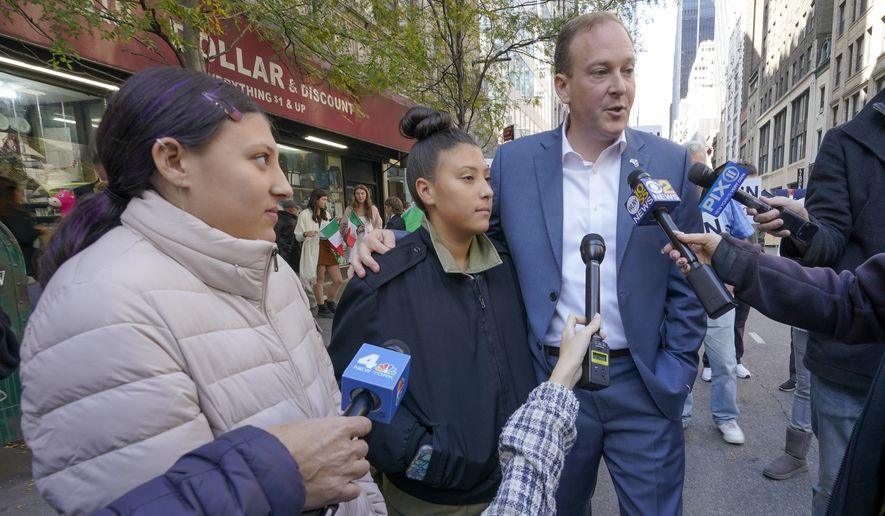 Republican candidate for New York Governor Congressman Lee Zeldin, right, stands with his daughters Arianna, center, and Mikayla, left, as he speaks to reporters before marching in the annual Columbus Day Parade, Monday, Oct. 10, 2022, in New York. (AP Photo/Mary Altaffer)
