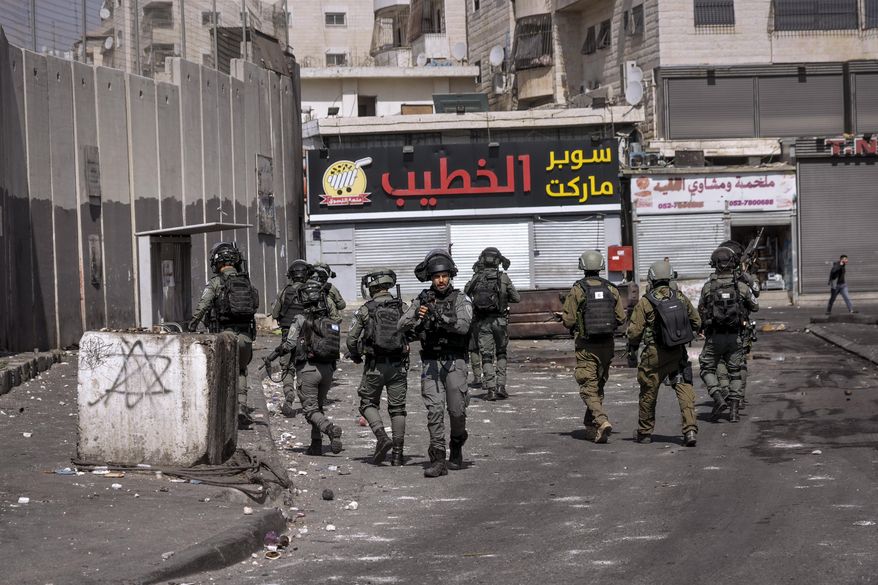 Israeli security forces patrol in Shuafat refugee camp in Jerusalem, Monday, Oct. 10, 2022. A manhunt follows a Saturday shooting attack at a military checkpoint in east Jerusalem where a Palestinian gunman fled from the scene after he opened fire, killing a female Israeli soldier and wounding three others, one of them seriously. (AP Photo/Mahmoud Illean)