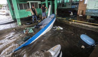 Fishermen look at boats partially submerged in water after Hurricane Julia swept through the area in Bluefields, Nicaragua, Sunday, Oct. 9, 2022. Hurricane Julia hit Nicaragua&#39;s central Caribbean coast and dumped torrential rains across Central America before reemerging over the Pacific as a tropical storm. (AP Photo/Inti Ocon)