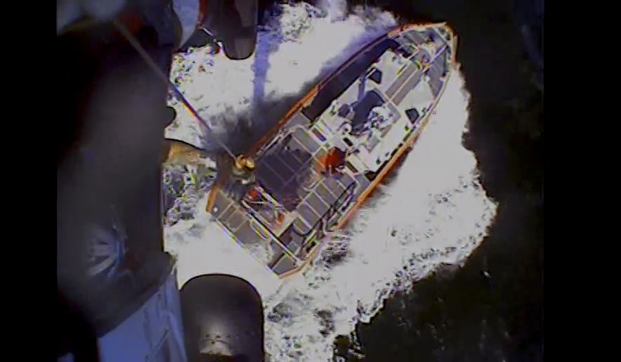 In this screenshot from video, the U.S. Coast Guard rescues boaters off the coast of Empire, La., on Sunday, Oct. 9, 2022. Three men whose fishing boat sank in the Gulf of Mexico off the Louisiana coast were rescued after surviving for more than a day despite being attacked by sharks that inflicted deep cuts on their hands and shredded one of their life jackets, according to their rescuers. (U.S. Coast Guard via AP)