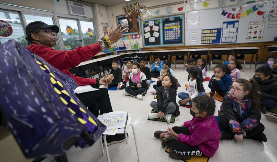 Ian Ellis James, an Emmy award-winning Sesame Street writer known by his stage name William Electric Black, leads a first grade class in a book reading on urban gun violence prevention at the Drexel Avenue School, Monday, Oct. 3, 2022, in Westbury, New York. (AP Photo/John Minchillo)