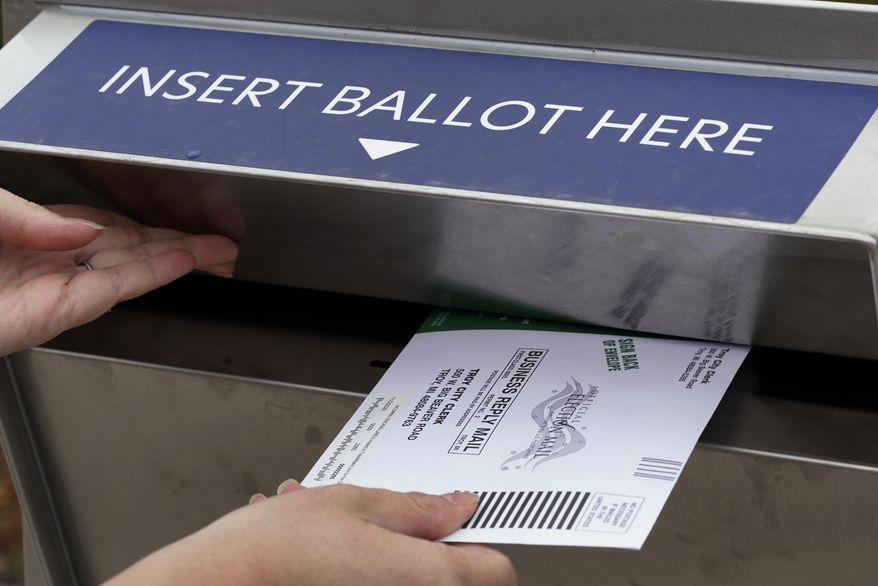 FILE — A Michigan voter inserts her absentee voter ballot into a drop box in Troy, Mich on Oct. 15, 2020. A total of 1.6 million people have requested absentee ballots so far this year, surpassing the 1.16 million who chose the option in the 2018 midterm election. (AP Photo/Paul Sancya, File)